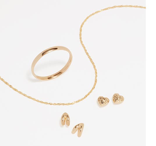 Gold-tone earrings, a necklace and a ring sit on a white background.