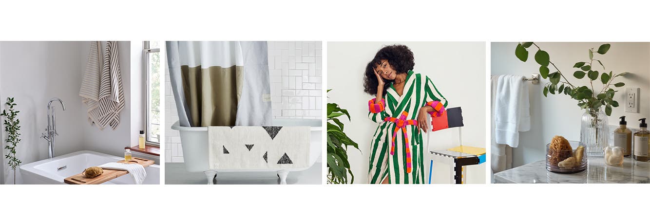 Hanging towels, a shower curtain and rug, a model in a bathrobe and bath products on a counter.