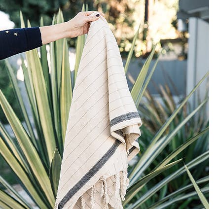 A cream and grey fringed towel.