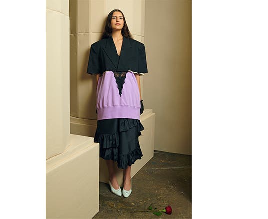 Model wearing a lace and fleece tank, cropped blazer, tiered skirt and pumps.