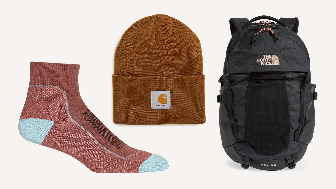 A multicolored hiking sock; a brown beanie; a black and grey North Face backpack.