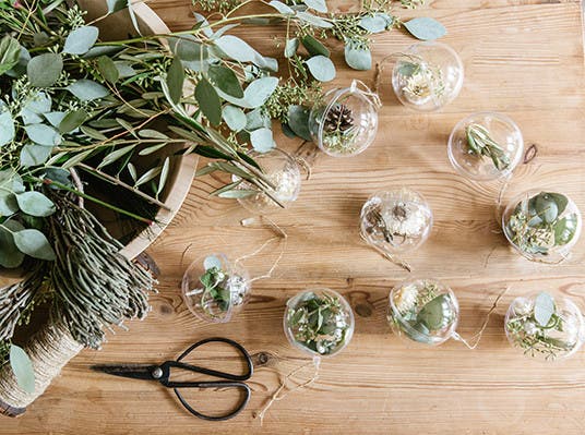 Clear round ornaments filled with greenery and pinecones by Jenni Kayne.