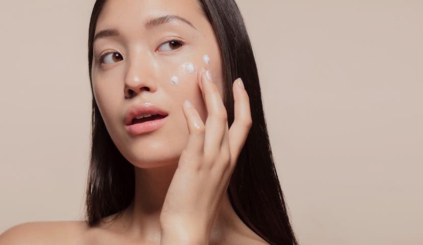 korean girl applying lotion to her face