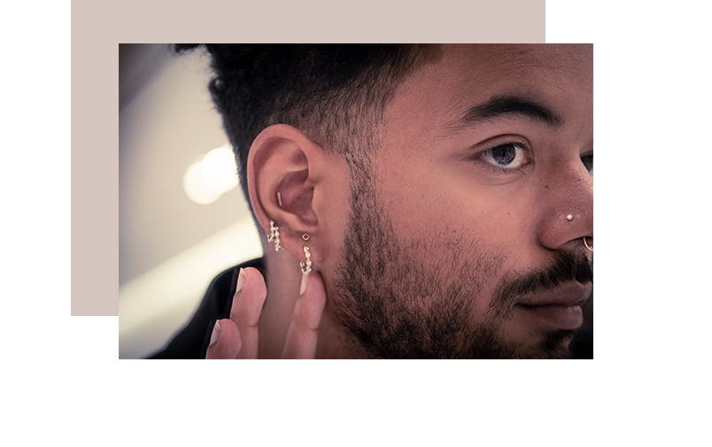 A customer shows off his curated ear piercings.
