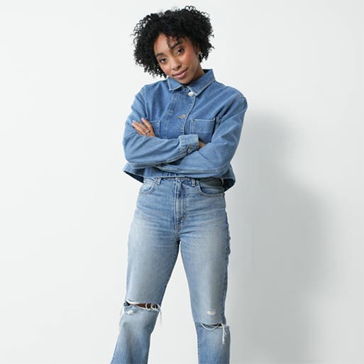 A woman wearing a denim shirt and jeans.