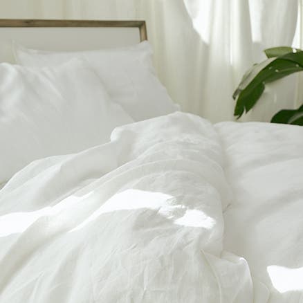 A bed with white pillows and duvet.