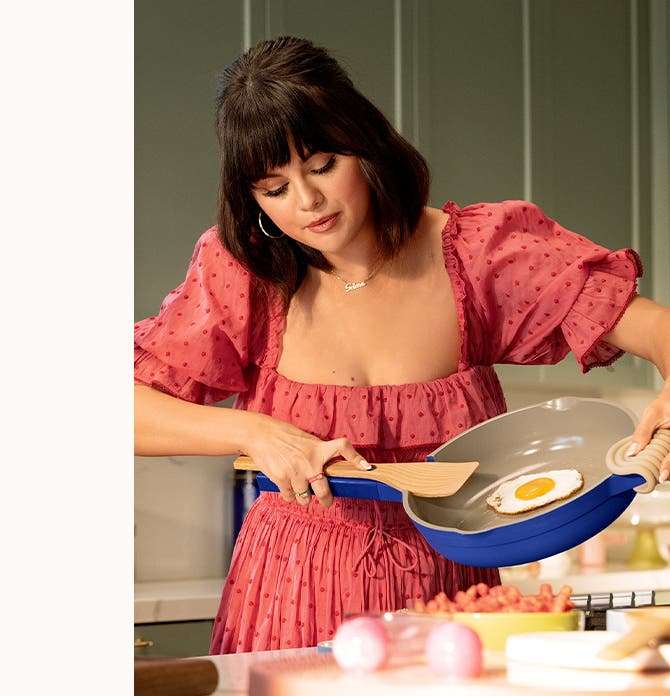 Selena Gomez frying an egg. Selena Gomez cooking with the Perfect Pot. Selena Gomez holding the Always Pan.