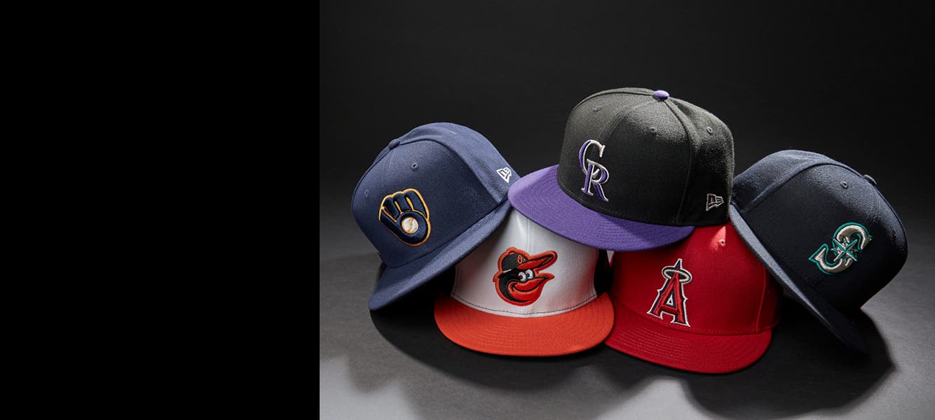 Gear up for game day: 5 hats featuring logos of different MLB teams; a drawer full of T-shirts with team logos; an Oklahoma sweatshirt and cap.