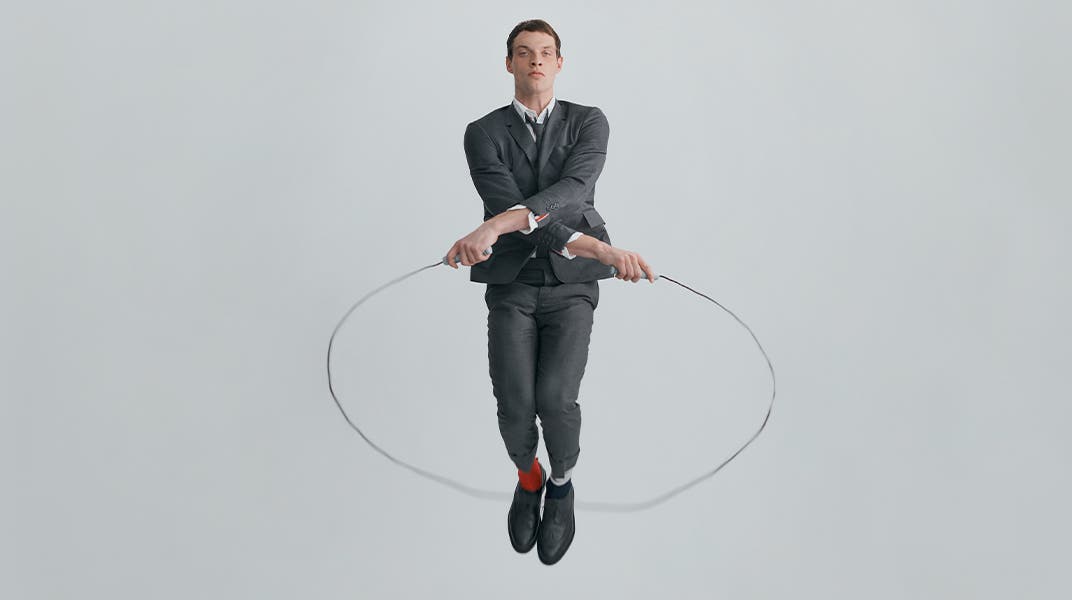Male model jumping rope in Thom Browne designs.