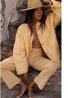 A woman wearing a quilted jacket and pants from Billabong.