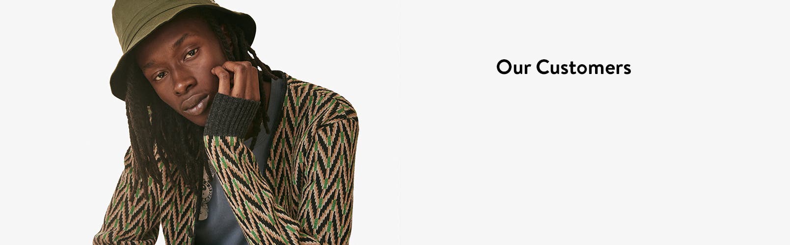 A man in hat and a patterned cardigan.