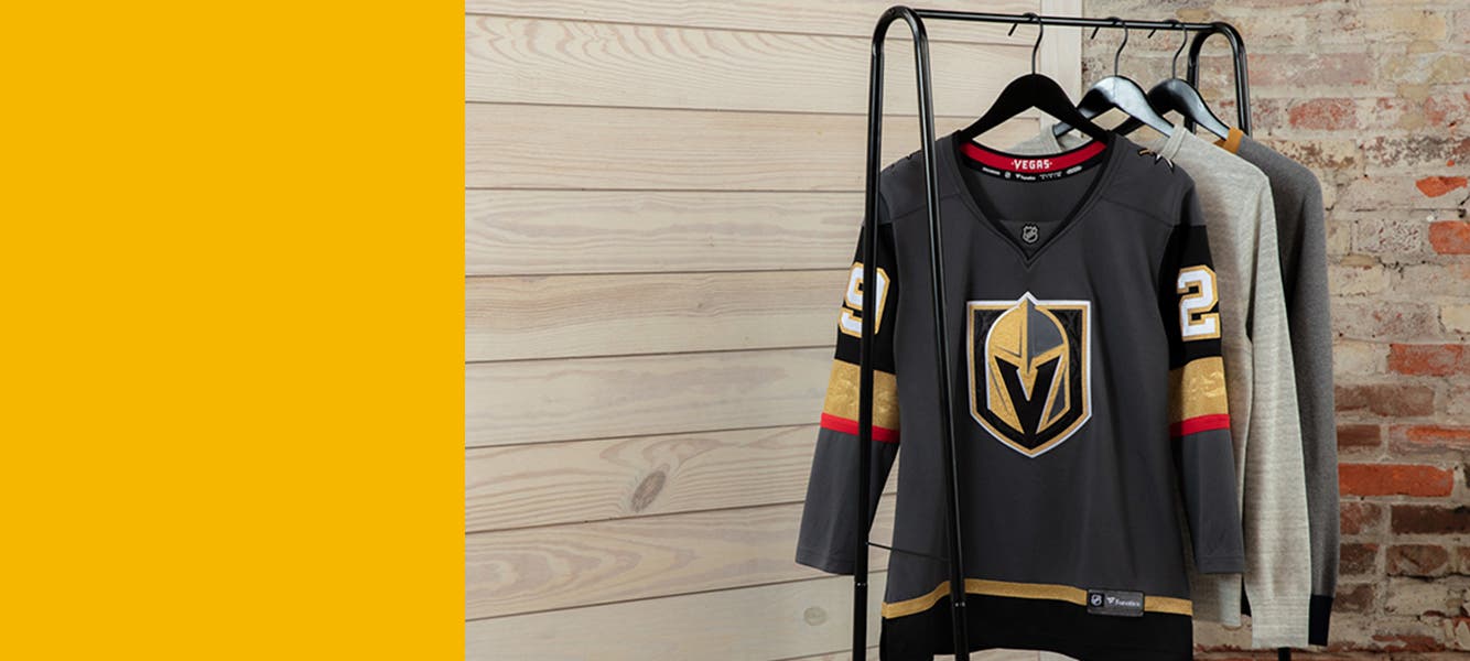 Several sweatshirts hang on a rack including one featuring branding for the Vegas Golden Knights hockey team.
