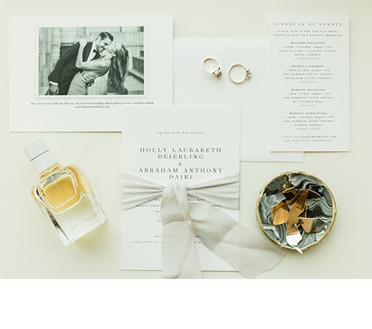 Wedding items, including the invitation and their rings, for bride and groom Holly and Abraham.