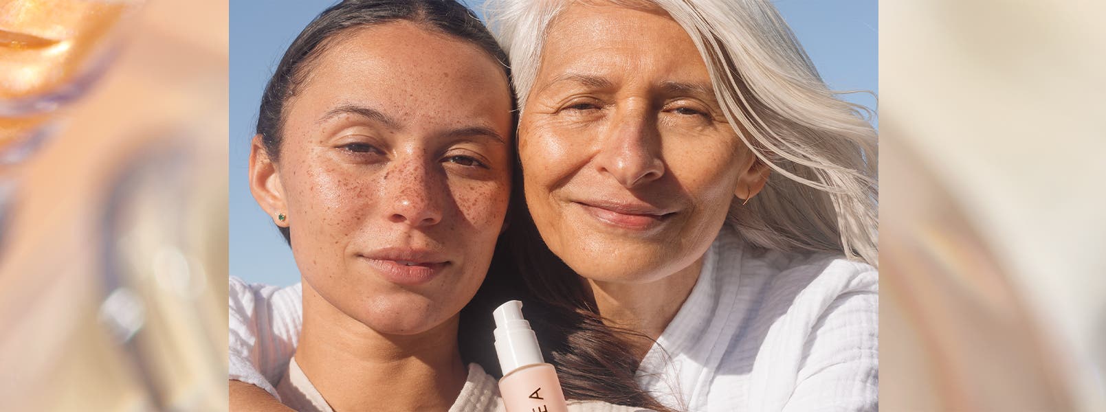 A young woman and an older woman pose together.