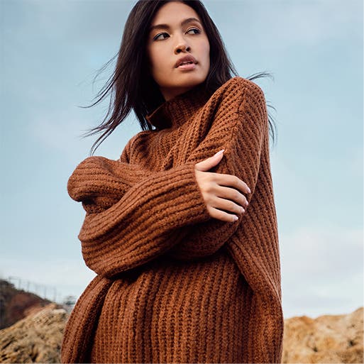 A model wearing a brown sweater.