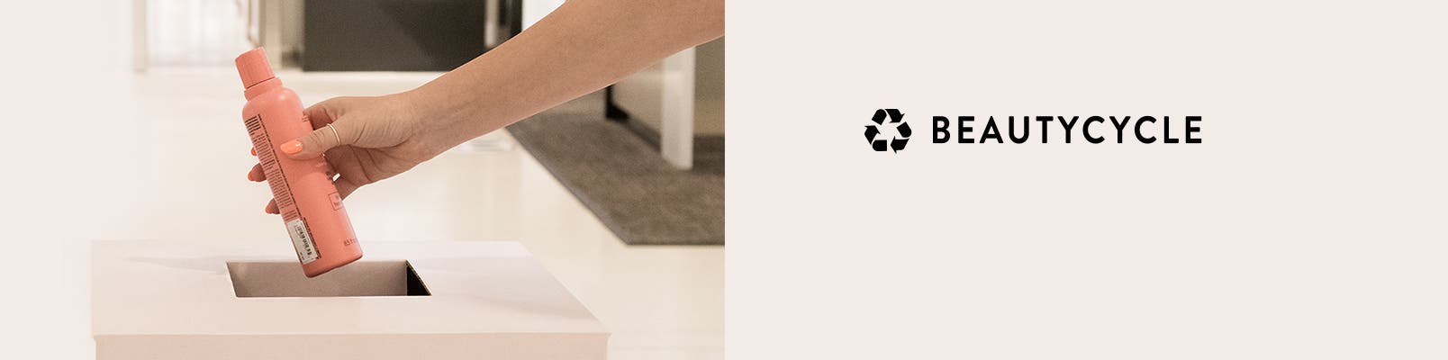 An empty shampoo bottle being placed in a BEAUTYCYCLE bin.
