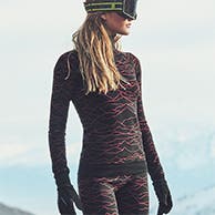 A woman wearing ski base layers and goggles.