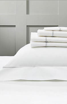 Folded bed sheets on top of a euro sham.