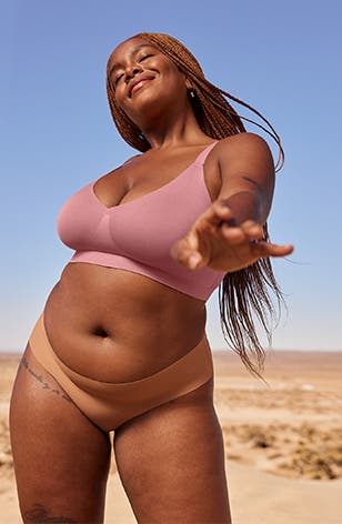 A model wearing a pink bra and brown panties.