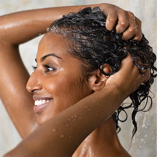 A woman shampoos her hair.