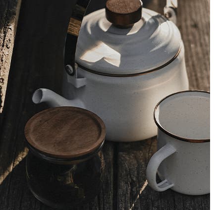 A white enamel kettle and mug.