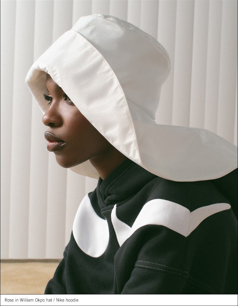 Model wearing a hat and hoodie.