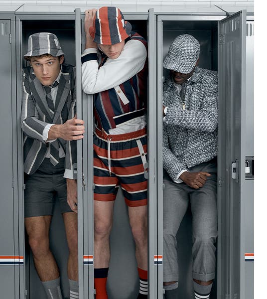 Male models in Thom Browne designs inside lockers.