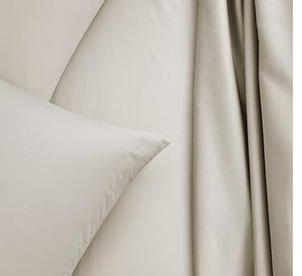 A closeup of white cotton sheets.