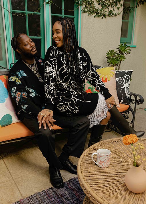 Cristina sits on her partner's lap, and both wear Nordstrom by Cristina Martinez knits.