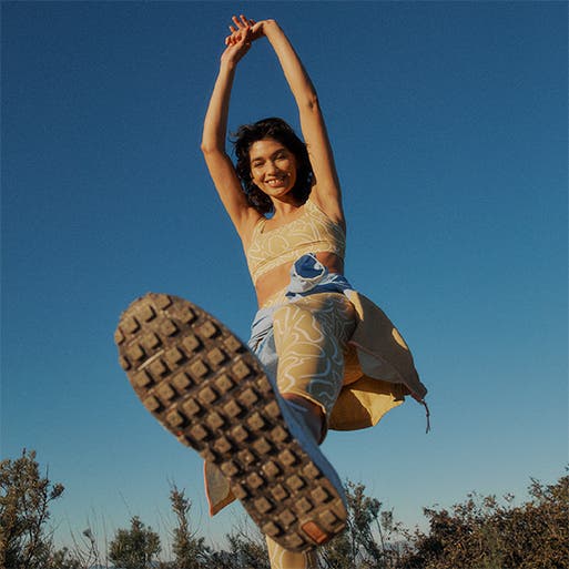 A woman wearing a matching activewear set with hiking shoes.
