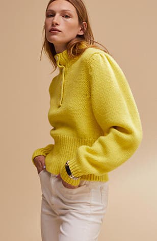 A woman wearing a yellow sweater.