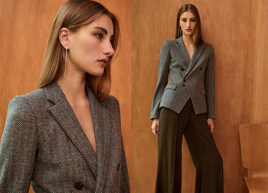 A woman in a herringbone jacket and brown wide-leg pants.
