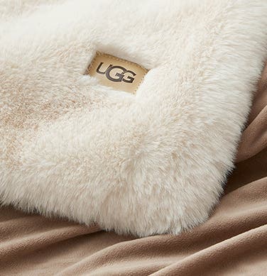 A neutral-toned UGG throw blanket.