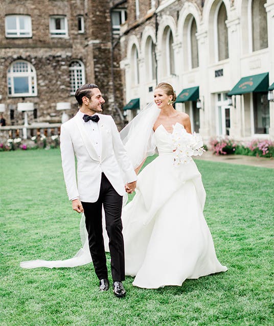 Newlyweds Holly and Abraham pose in an outdoor courtyard.