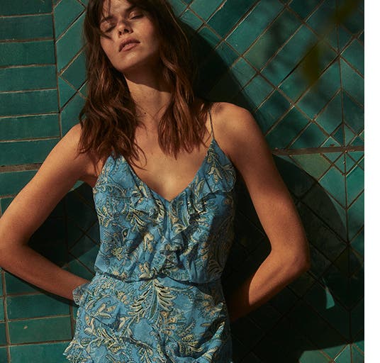 A model wearing a turquoise and green dress.