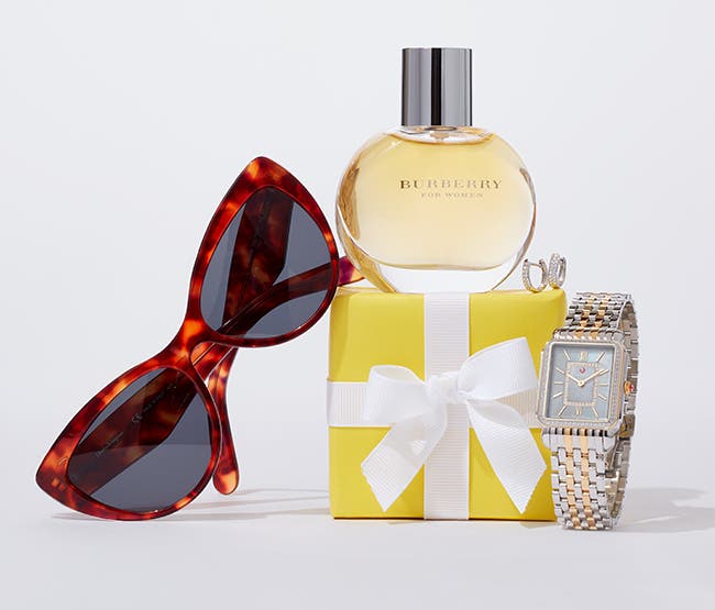 Cat-eye sunglasses; a bottle of Burberry fragrance atop a yellow gift box; and a gold and silver-tone watch.