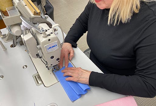 Nordstrom tailor sewing a COVID-19 mask.