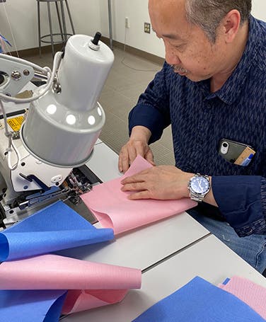 Nordstrom tailor sewing a COVID-19 mask.