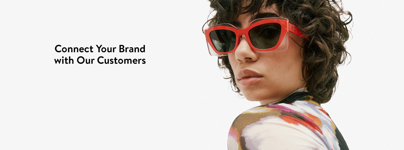 Connect Your Brand with Our Customers. A woman in red sunglasses looking over her shoulder.