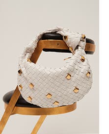 A white woven designer handbag.