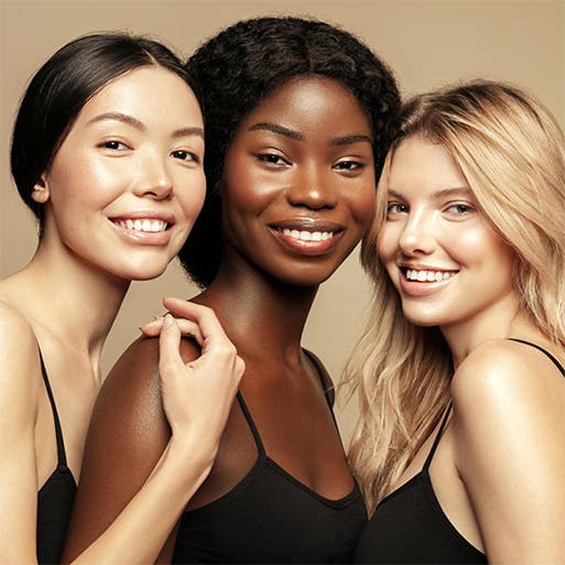 Three women with different hair textures smiling