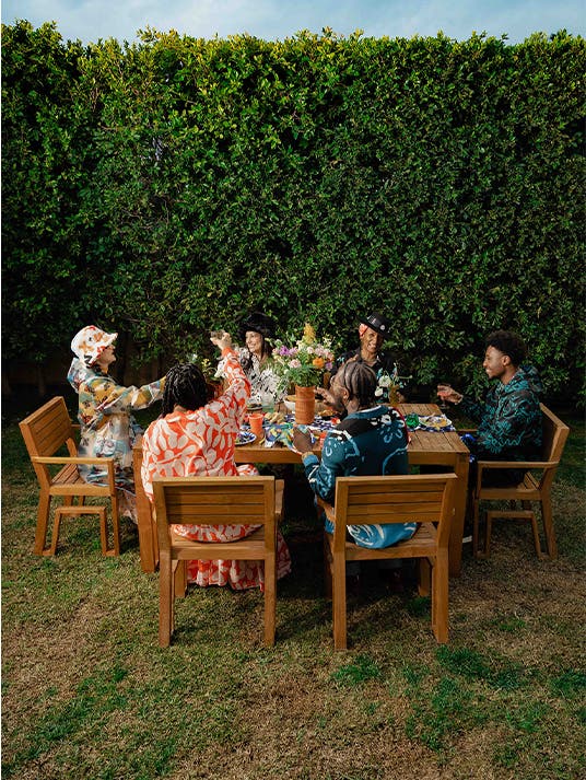 Cristina's collaborators gather around a dining table wearing Nordstrom by Cristina Martinez clothing.