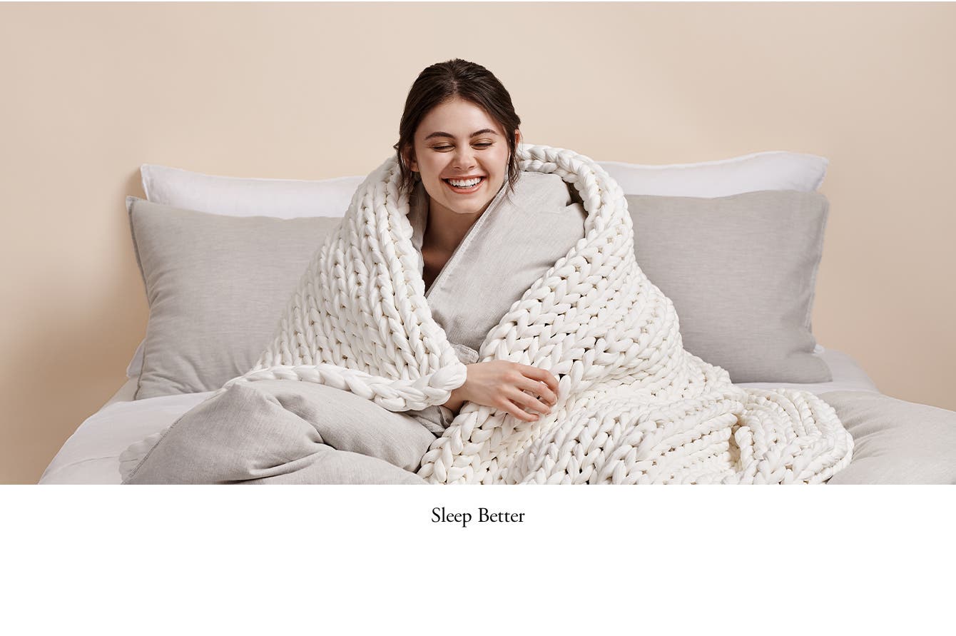 Sleep better. Woman enveloped in a weighted blanket.