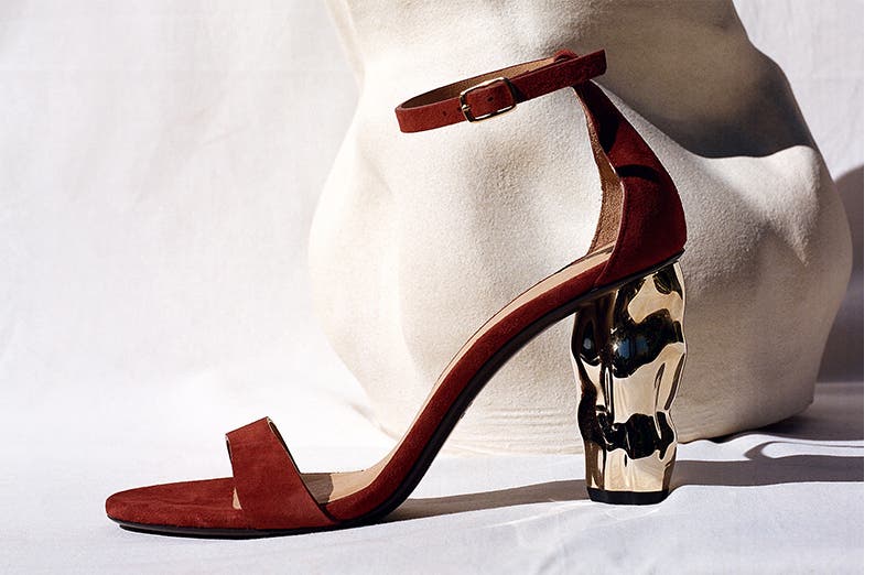 Maroon ankle-strap high heel with a high-shine architectural heel.