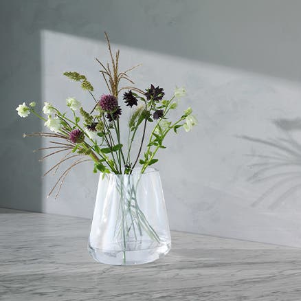 A clear glass vase holding cut flowers.