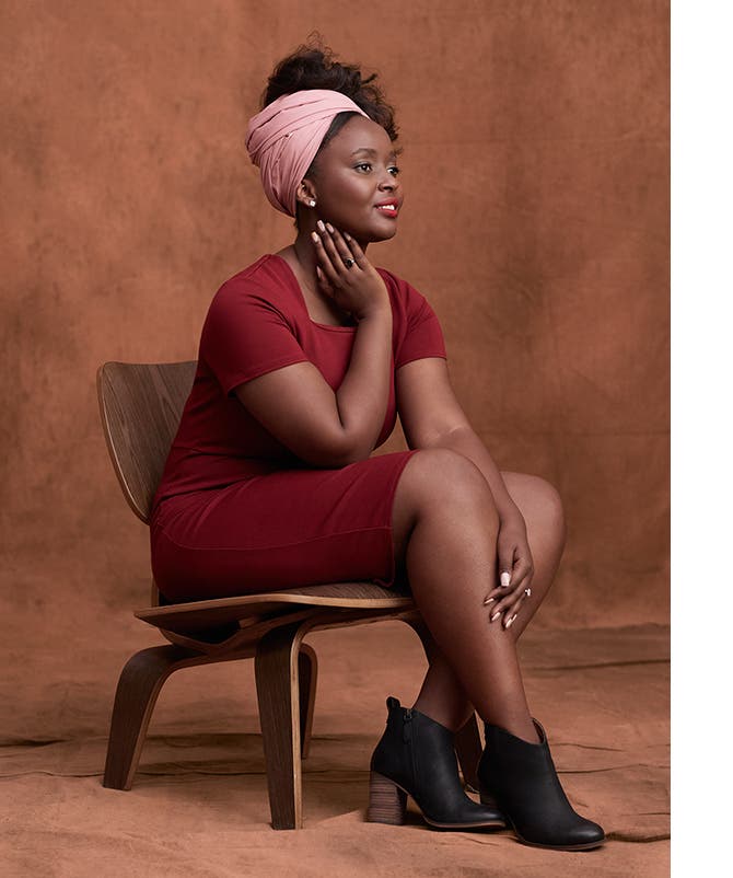 Natacha Karambizi wears a headwrap, dress and boots.
