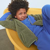 A kid wearing a fleece jacket and sweats.