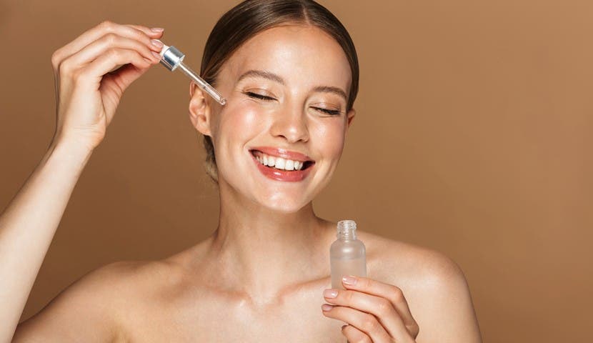 girl smiling applying face oil