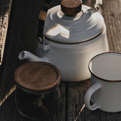 A white enamel kettle and mug.
