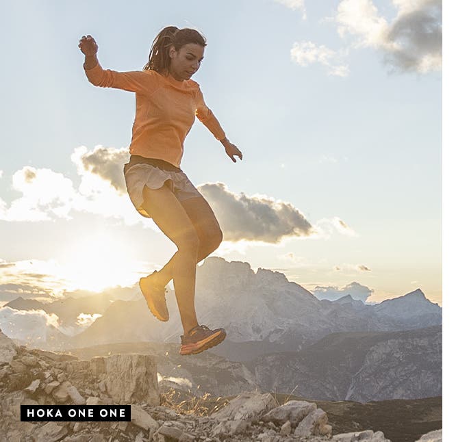 Woman and man trail running in shoes from HOKA ONE ONE.